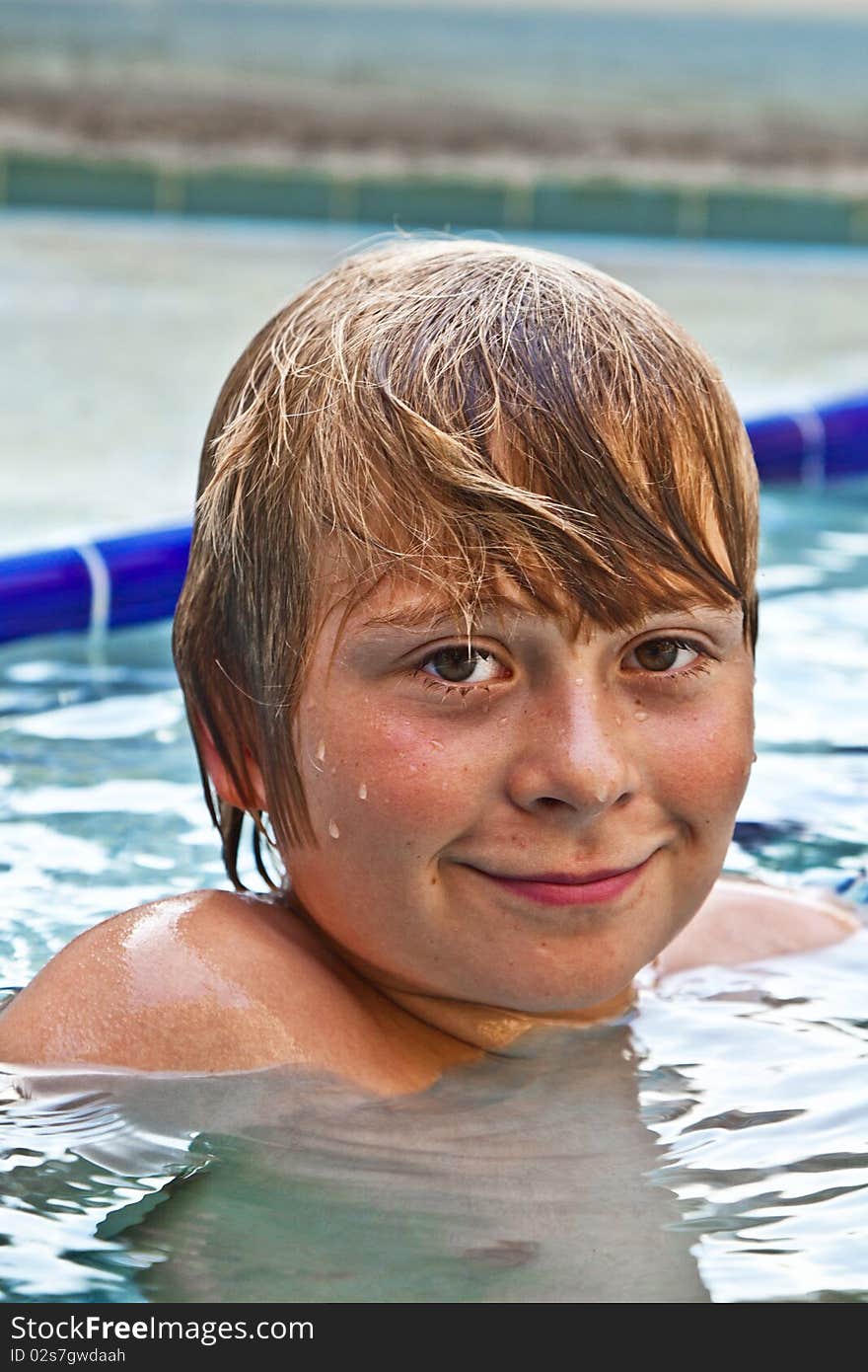 Boy enjoys swimming in an outdoor pool