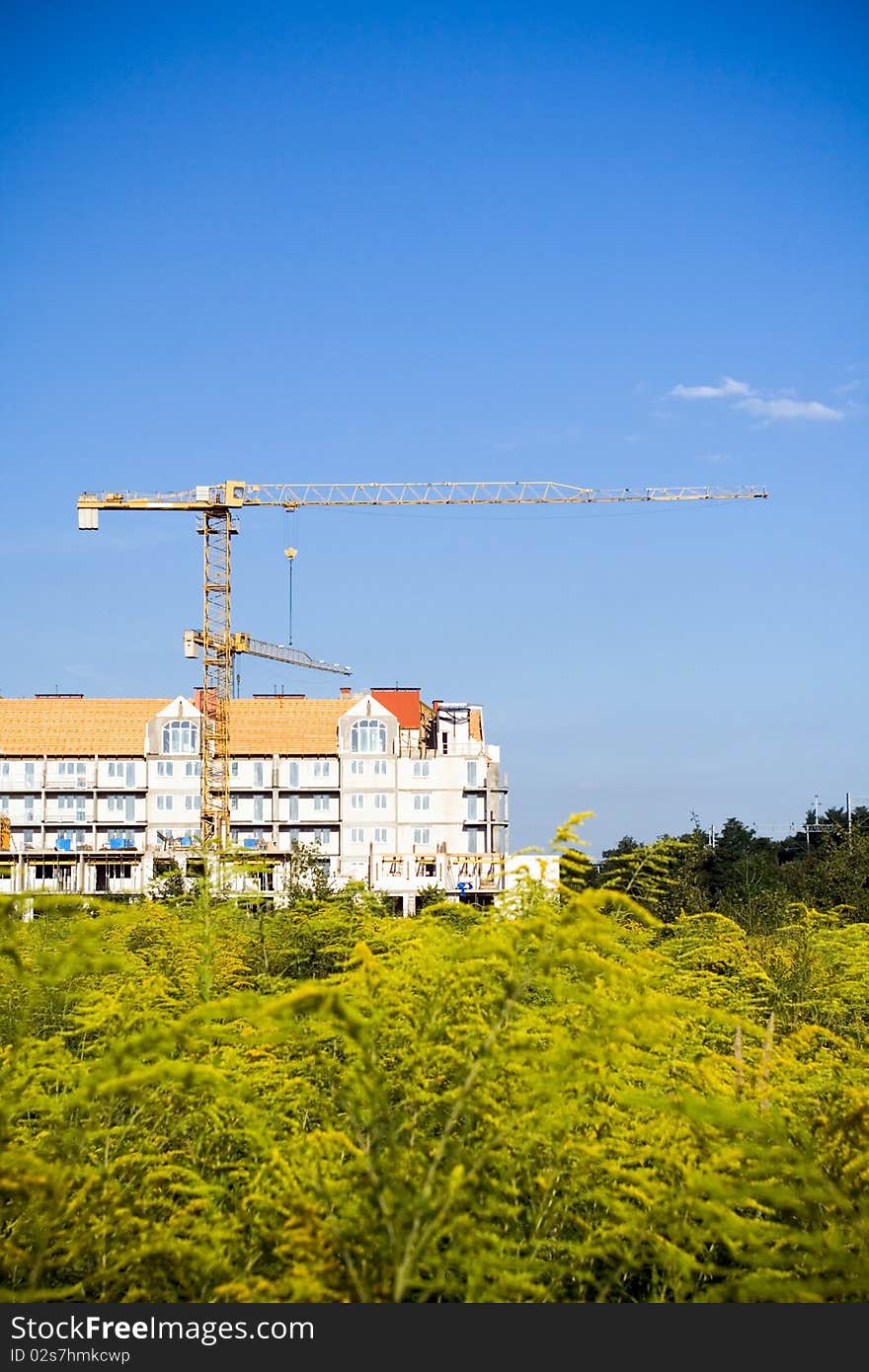 Green construction site over summer blue sky, building growth. Green construction site over summer blue sky, building growth