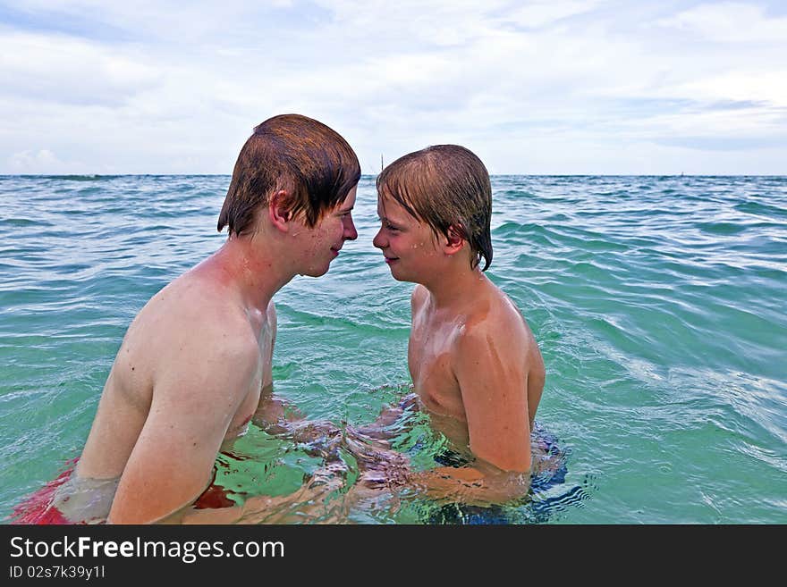 Boys having fun in the clear sea