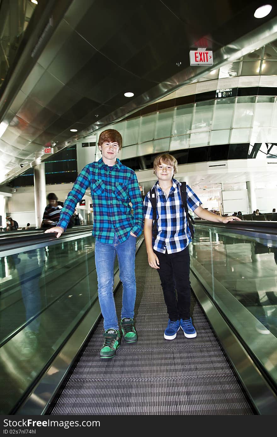 Young boys on a moving staircase at the airport