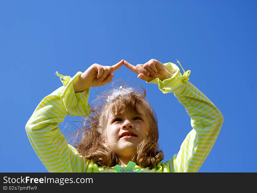 The girl draws in the dark blue sky fingers having lifted upwards hands. The girl draws in the dark blue sky fingers having lifted upwards hands