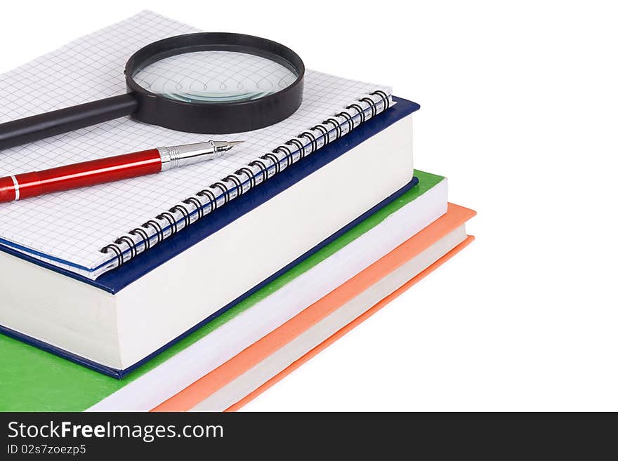 Magnifying glass and pen on books