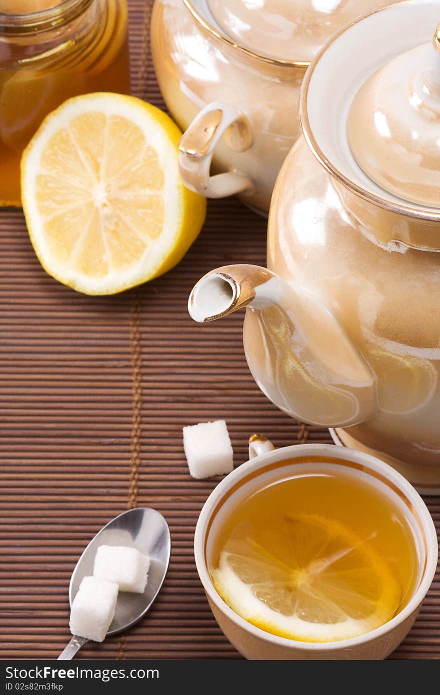 Tea, pot and honey on table