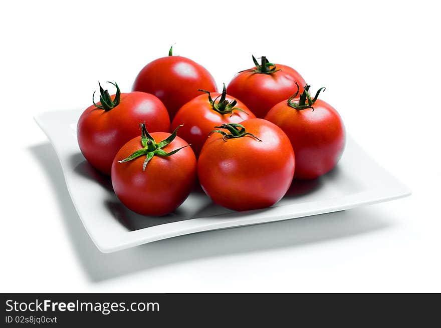 A shot of seven tomatoes on a plate