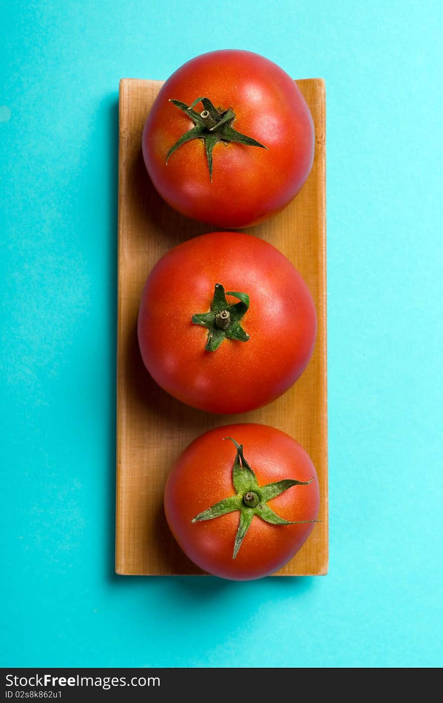 Ripe tomatoes on blue background