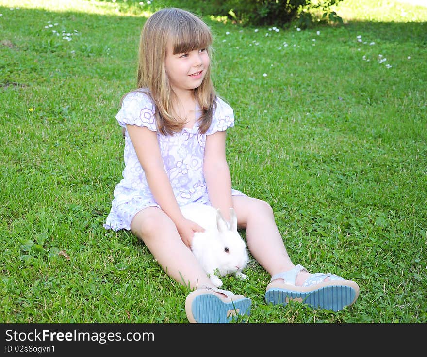 Girl with a rabbit in the grass. Girl with a rabbit in the grass