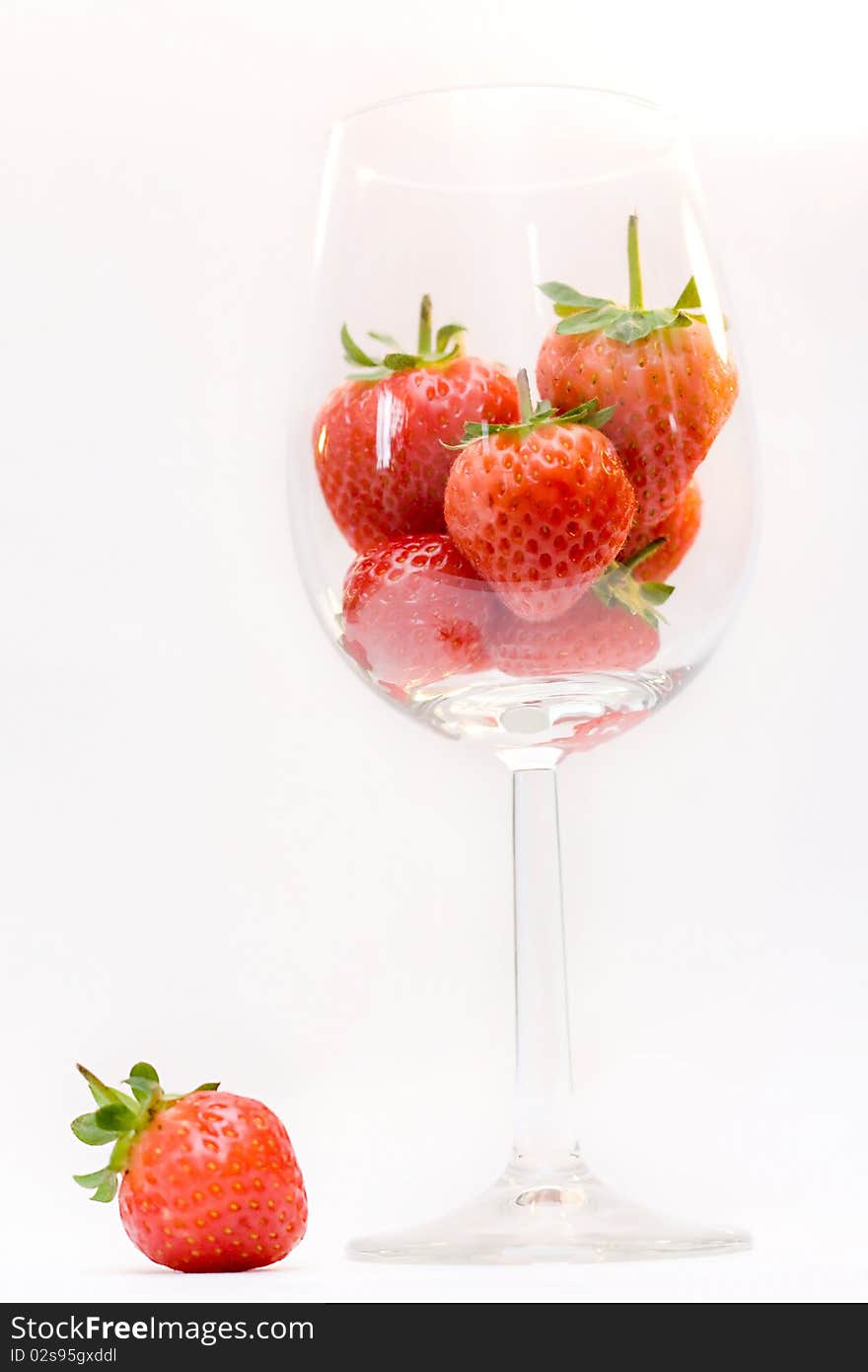 Strawberries in the wine glass isolated on white. Strawberries in the wine glass isolated on white