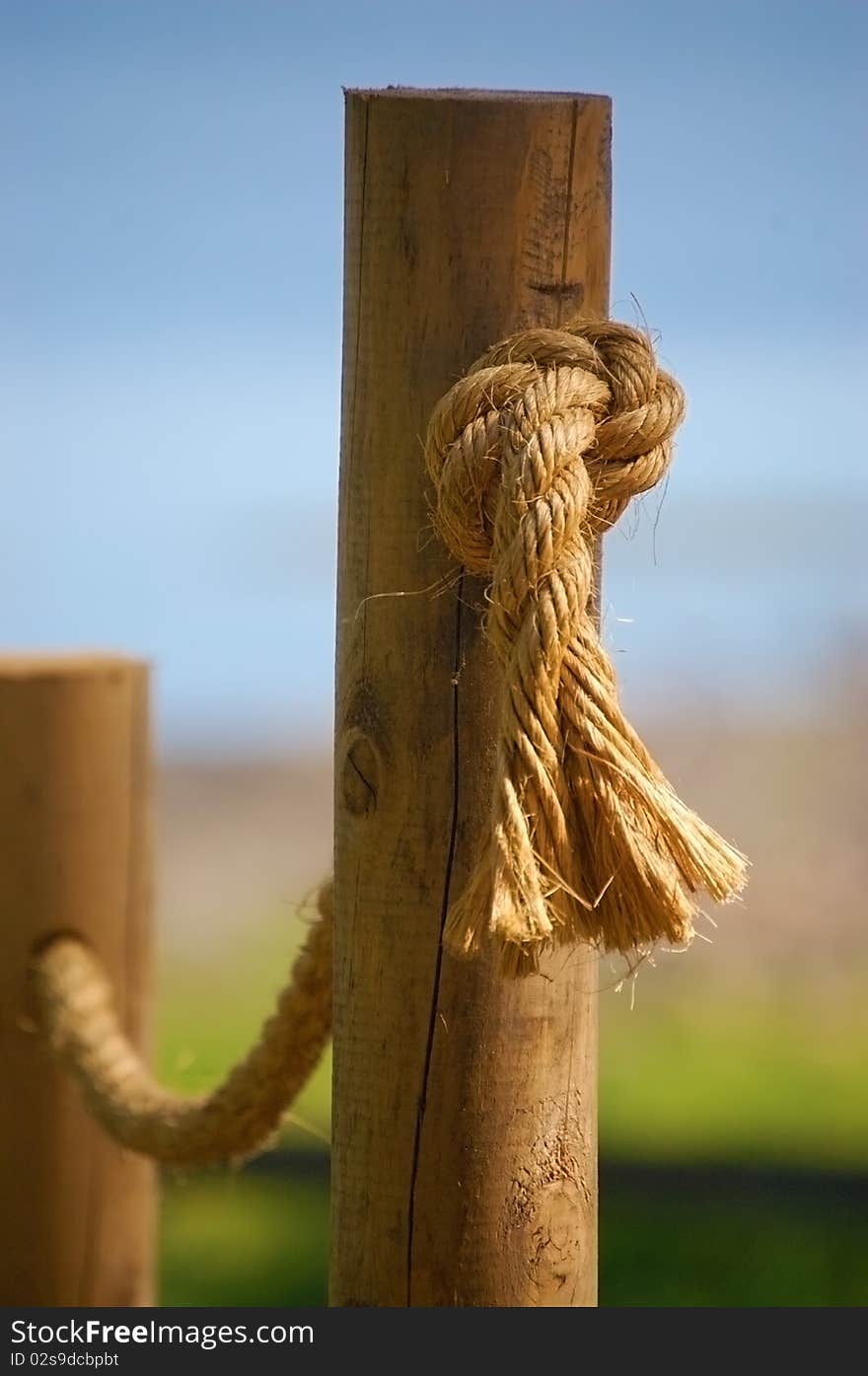 Detail of a rope handrail passing through round cedar posts. Detail of a rope handrail passing through round cedar posts