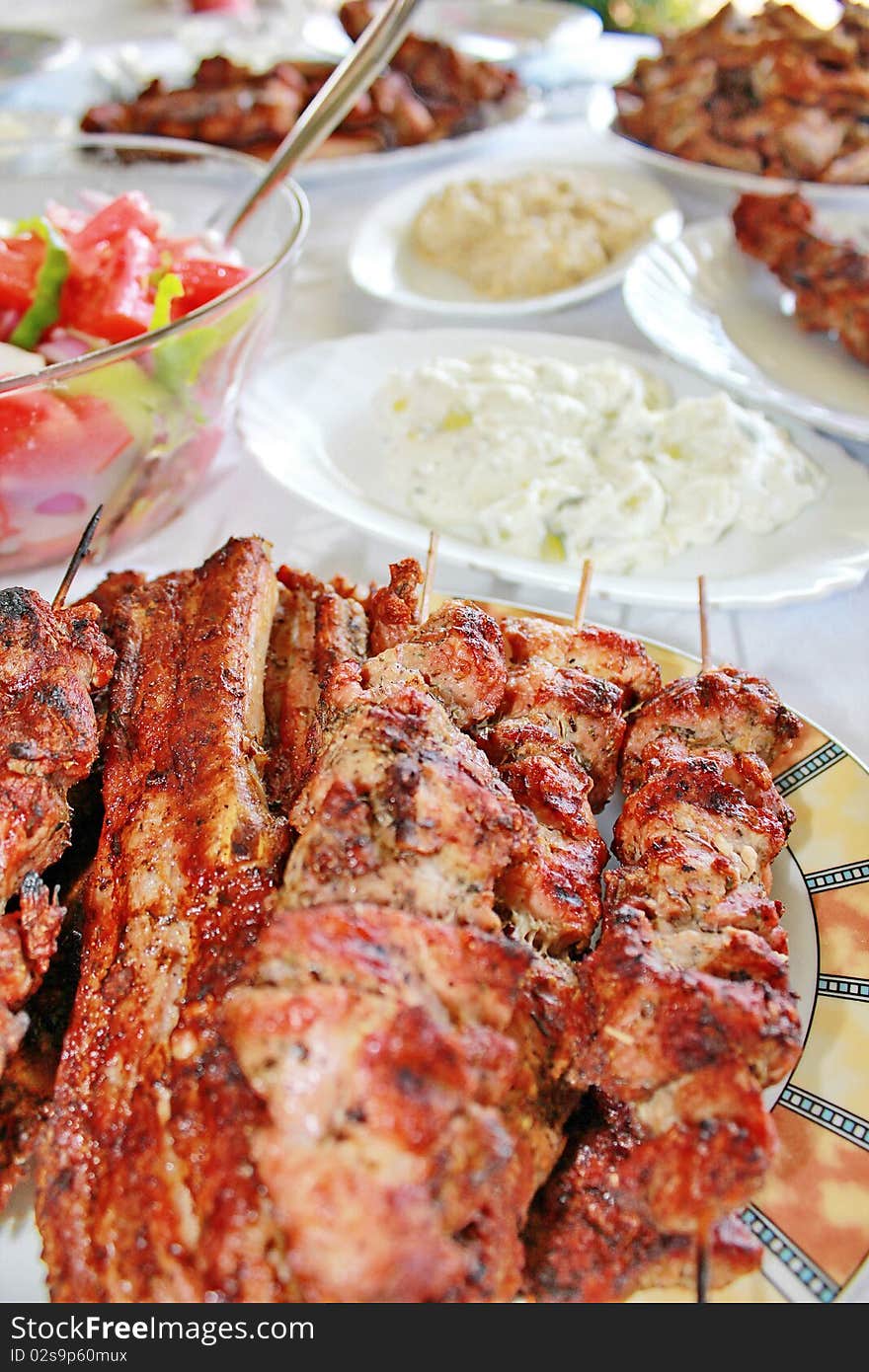 Variety traditional greek grilled meat souvlaki and chops and salads. Variety traditional greek grilled meat souvlaki and chops and salads