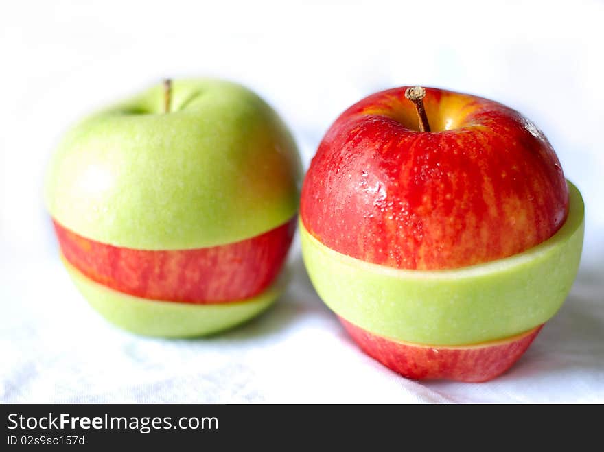 Red and green apples on the white ground