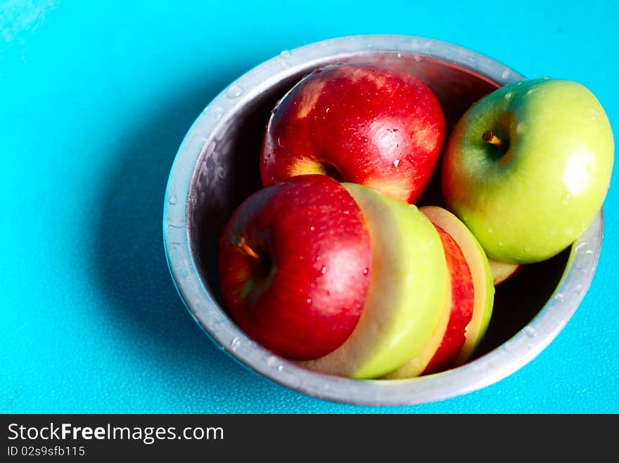 Red and green apples on the white ground