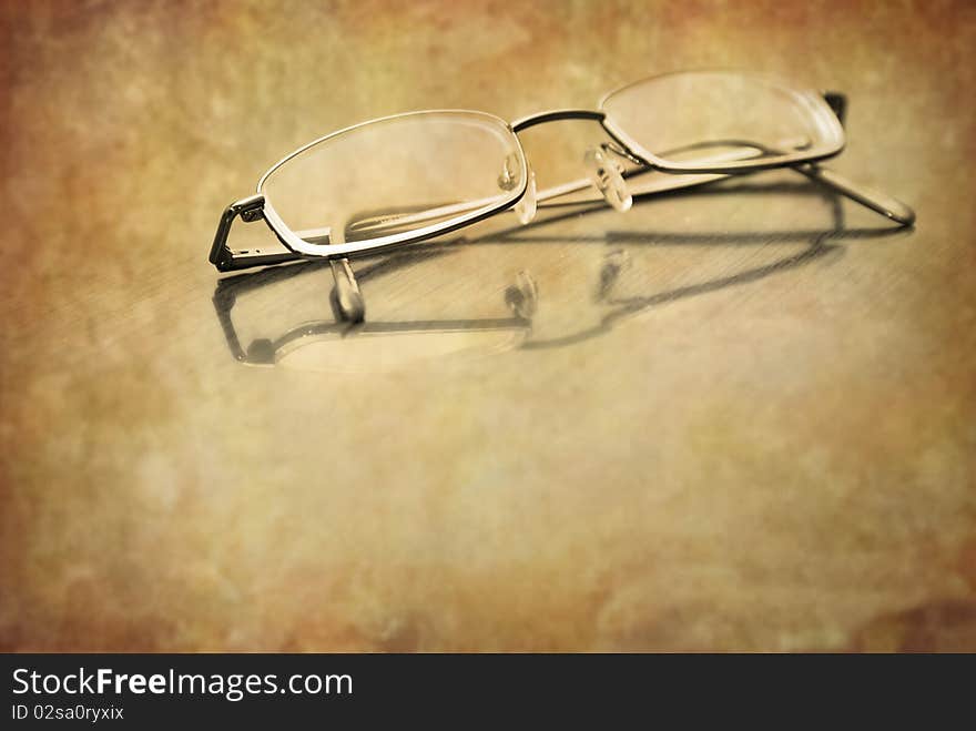 Closeup of Eyeglasses on top of a desk with reflection