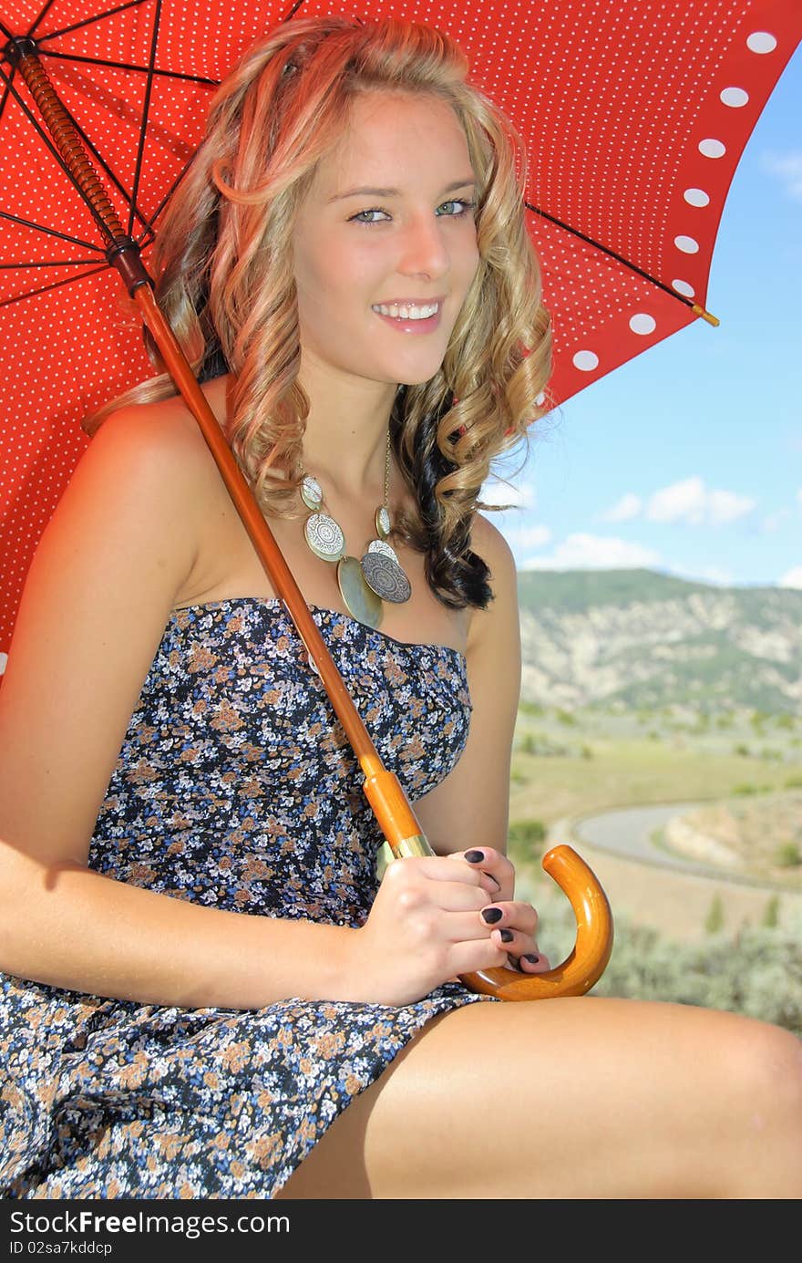 Girl with umbrella sit on rock. Girl with umbrella sit on rock