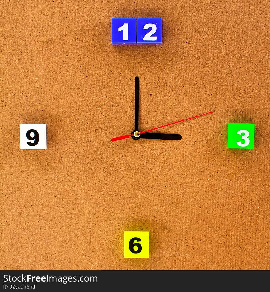 Colorful clock isolated on brown wood board