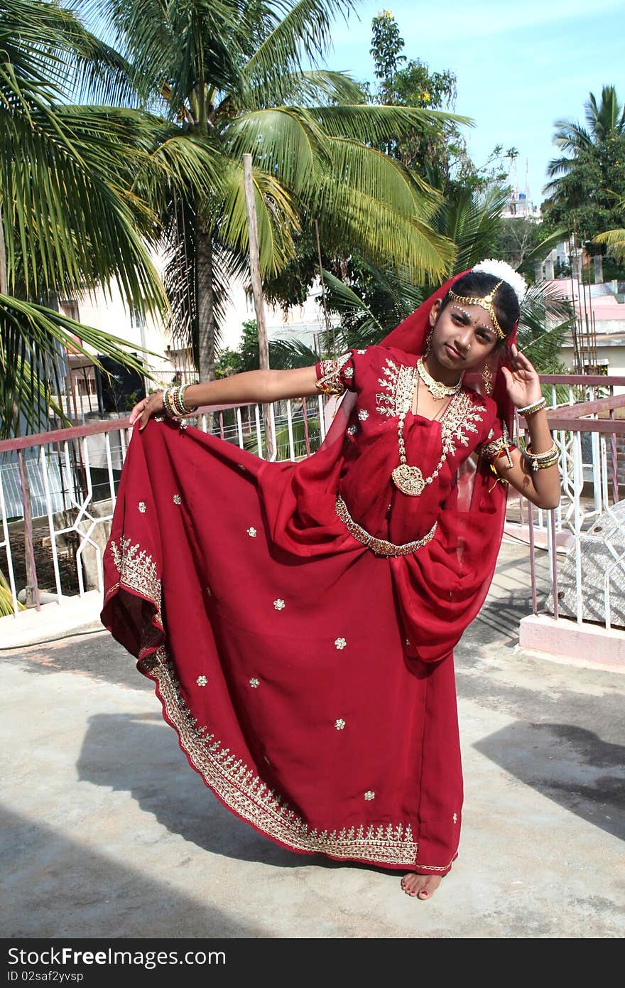 Indian girl in red dress sporting dance posture. Indian girl in red dress sporting dance posture