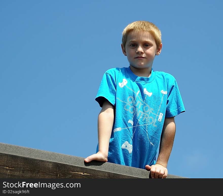 A cute young boy enjoys the park while posing for photographs on a summer day.