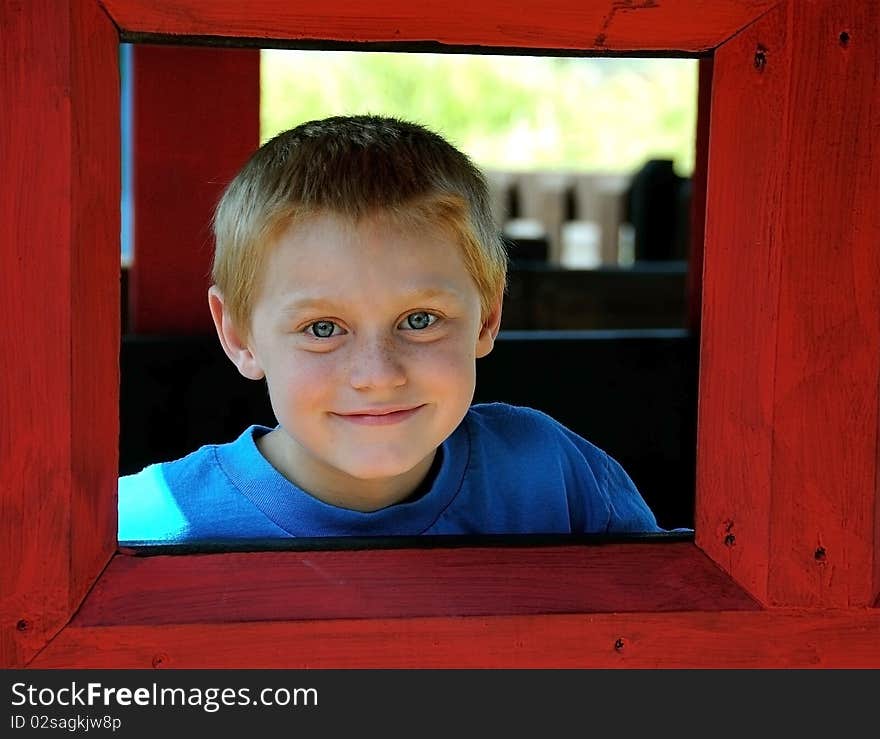 A cute young boy enjoys the park while posing for photographs on a summer day.