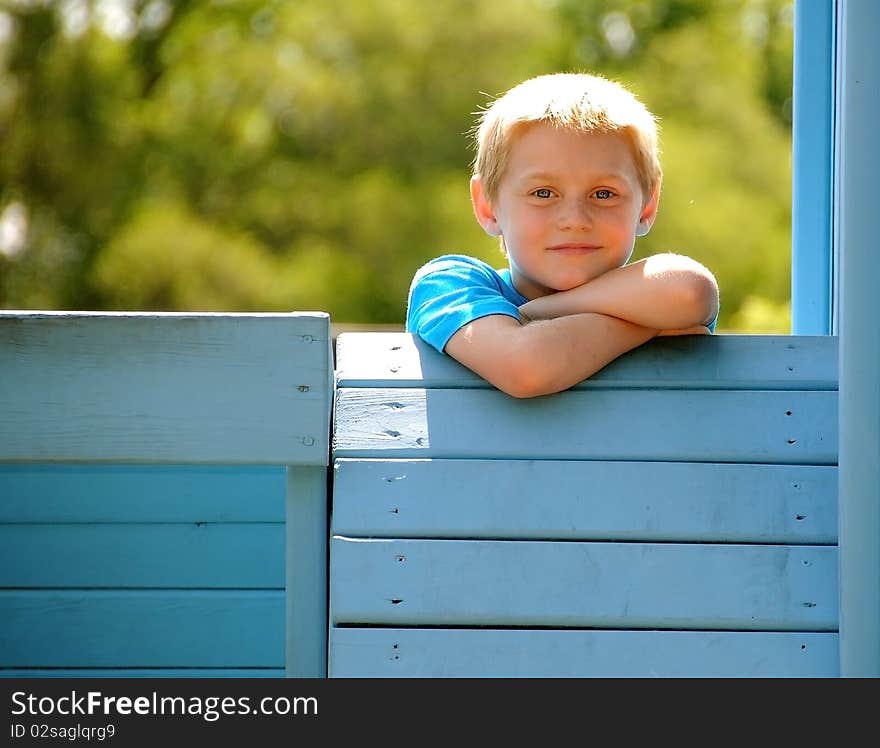 A cute young boy enjoys the park while posing for photographs on a summer day.