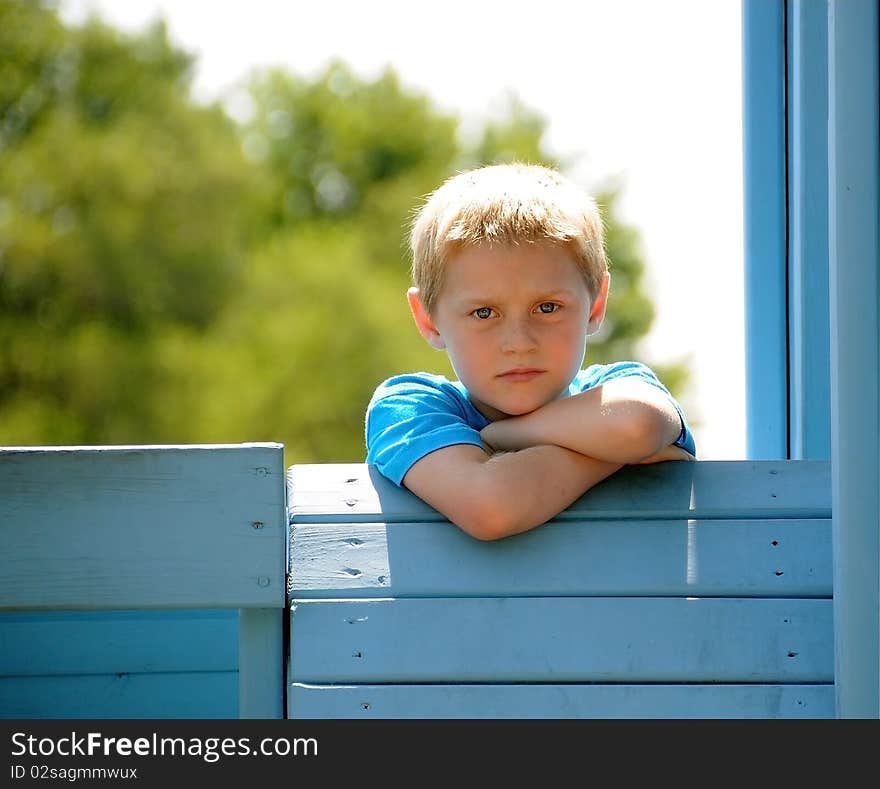 A cute young boy enjoys the park while posing for photographs on a summer day.