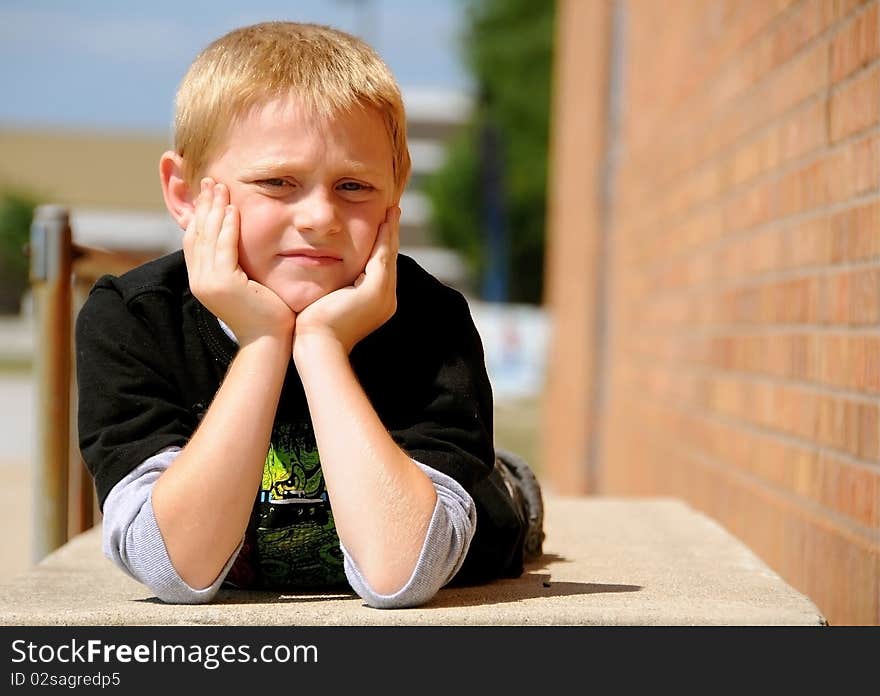 A young boy poses for photographs outside an urban building.