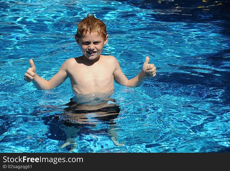 A young boy enjoys playing in the pool on a summer day.