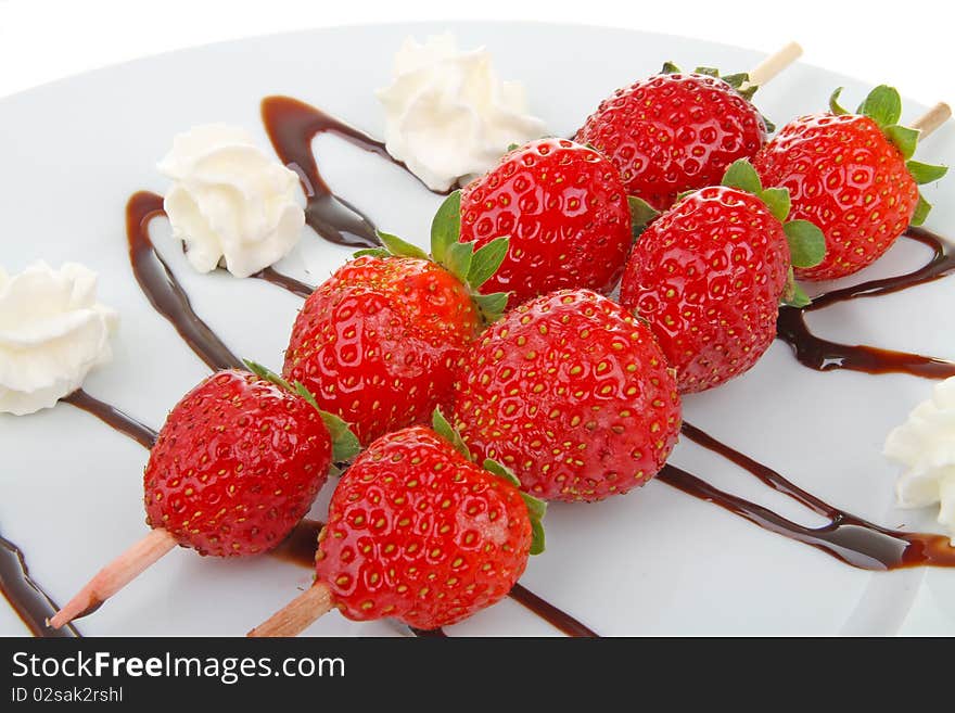 Two sweet skewers strawberry on plate. Two sweet skewers strawberry on plate