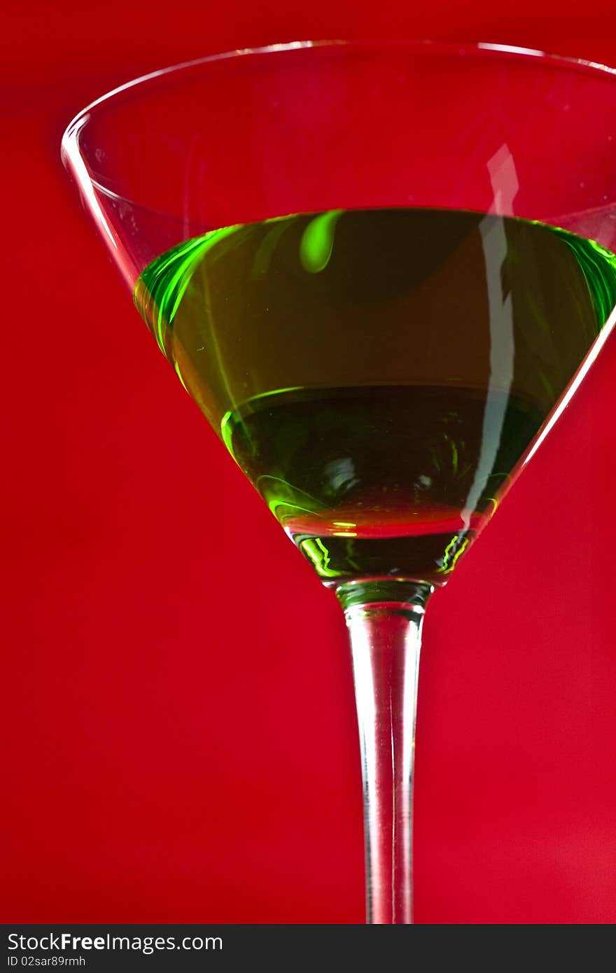 Green drinks in martini glass on red background