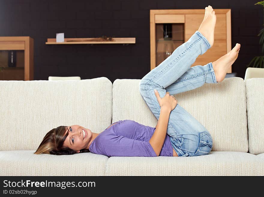 Woman in living room is smiling and relaxing. Woman in living room is smiling and relaxing