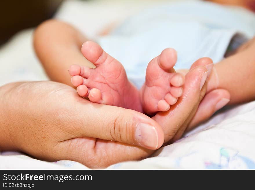 Baby's feet on mom's hand