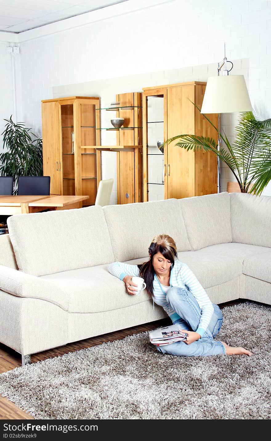 Woman in living room with coffee is smiling. Woman in living room with coffee is smiling