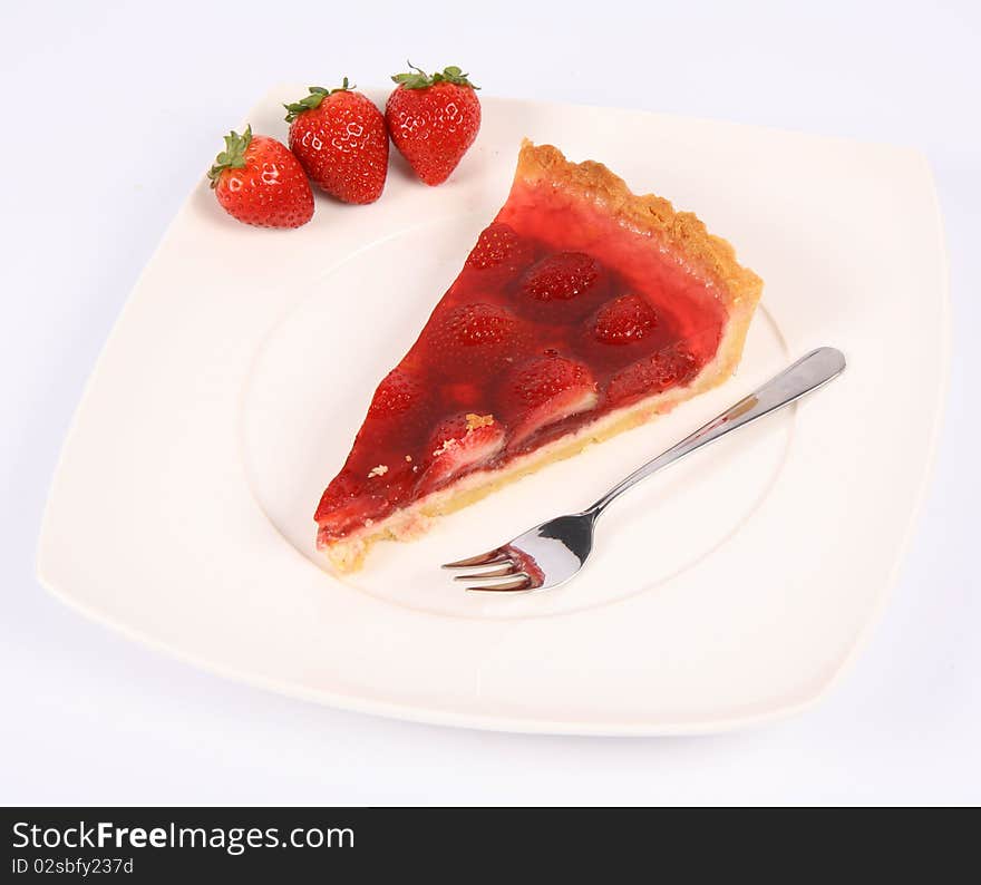 Piece of Strawberry Tart on a plate decorated with strawberries, and a fork