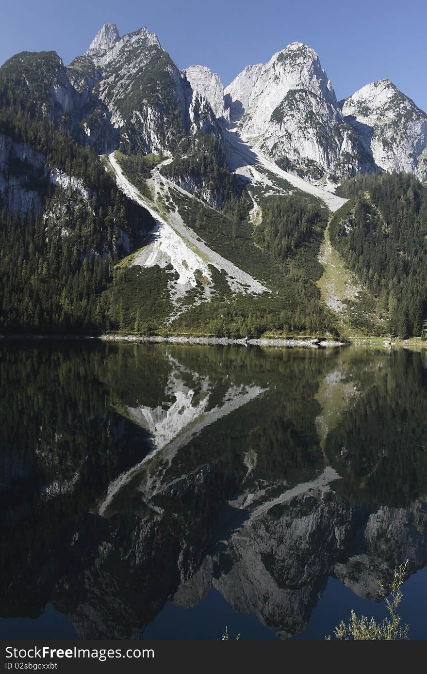 The mirroring peaks of dachstein glacier in the lake Gosau, which is a small lake in Salzamergut region, near village of Gosau. The mirroring peaks of dachstein glacier in the lake Gosau, which is a small lake in Salzamergut region, near village of Gosau.