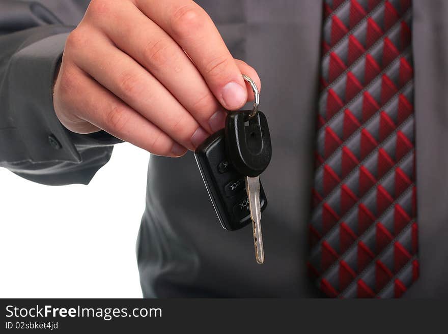 The businessman in a grey shirt and a tie stretches a car key. The businessman in a grey shirt and a tie stretches a car key.