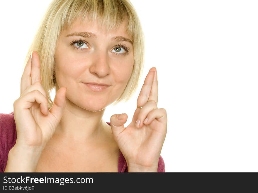 Beautiful young woman with fingers crossed over white background