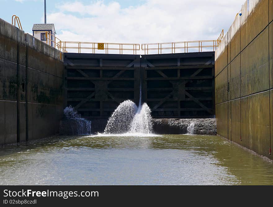 A Canal Lock filling with water to raise the lock for the next level.