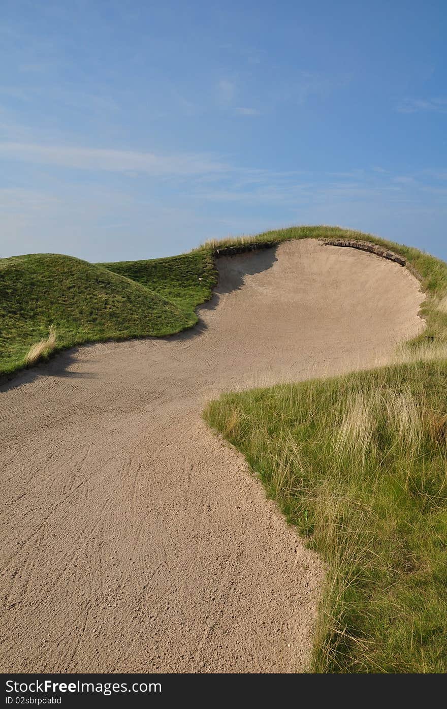 A severe bunker with a steep face. A severe bunker with a steep face