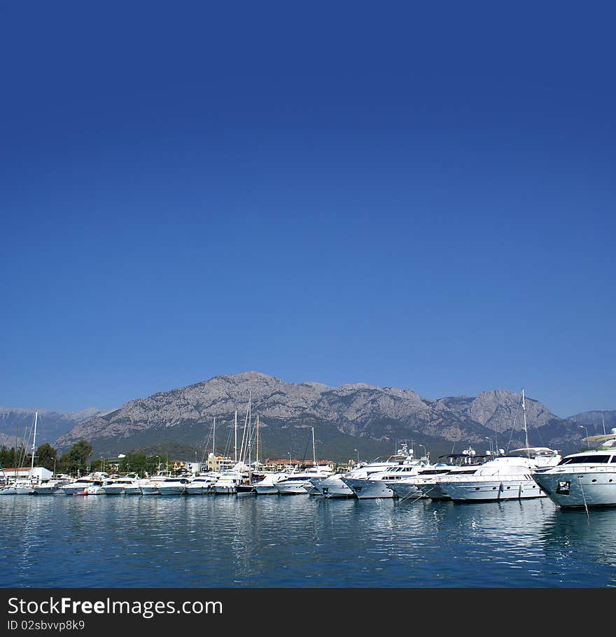 A lot of beautiful boats on a Mediterranean shore. The image is taken on a sky and water background.