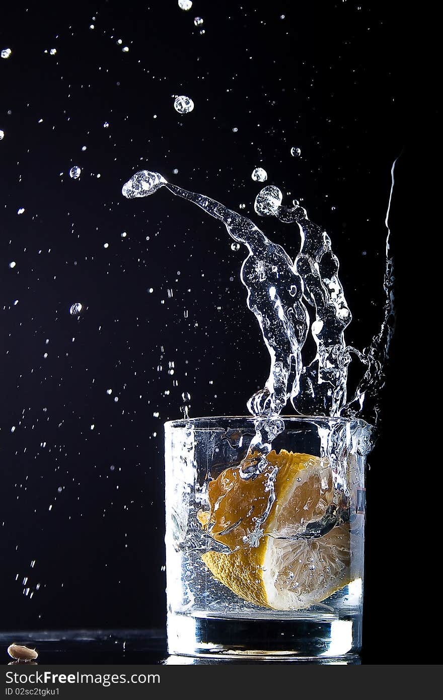 A lemon falls in glass