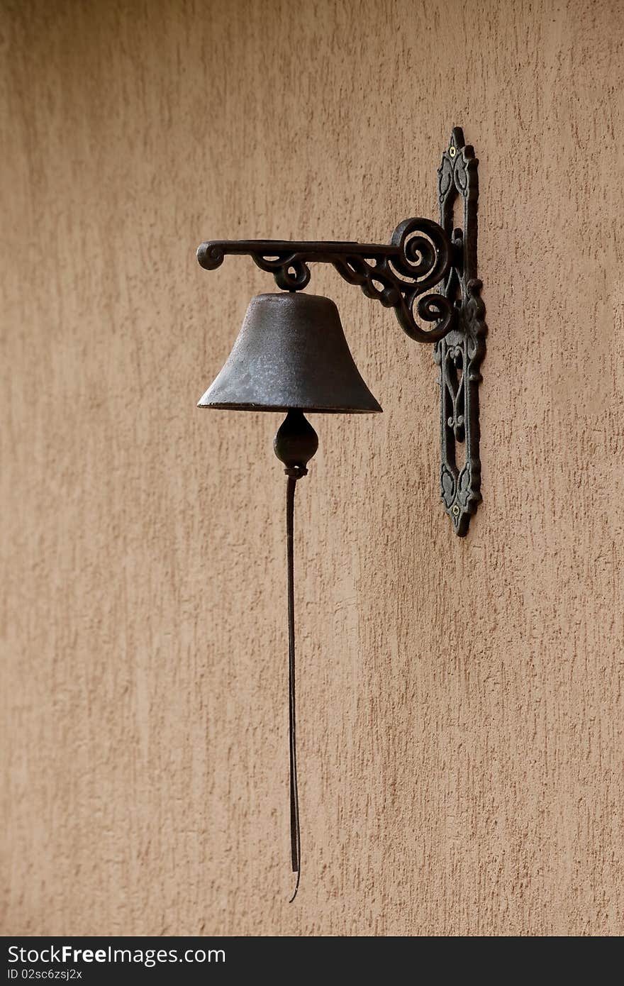 Closeup of antique rusty bell on stucco wall. Closeup of antique rusty bell on stucco wall