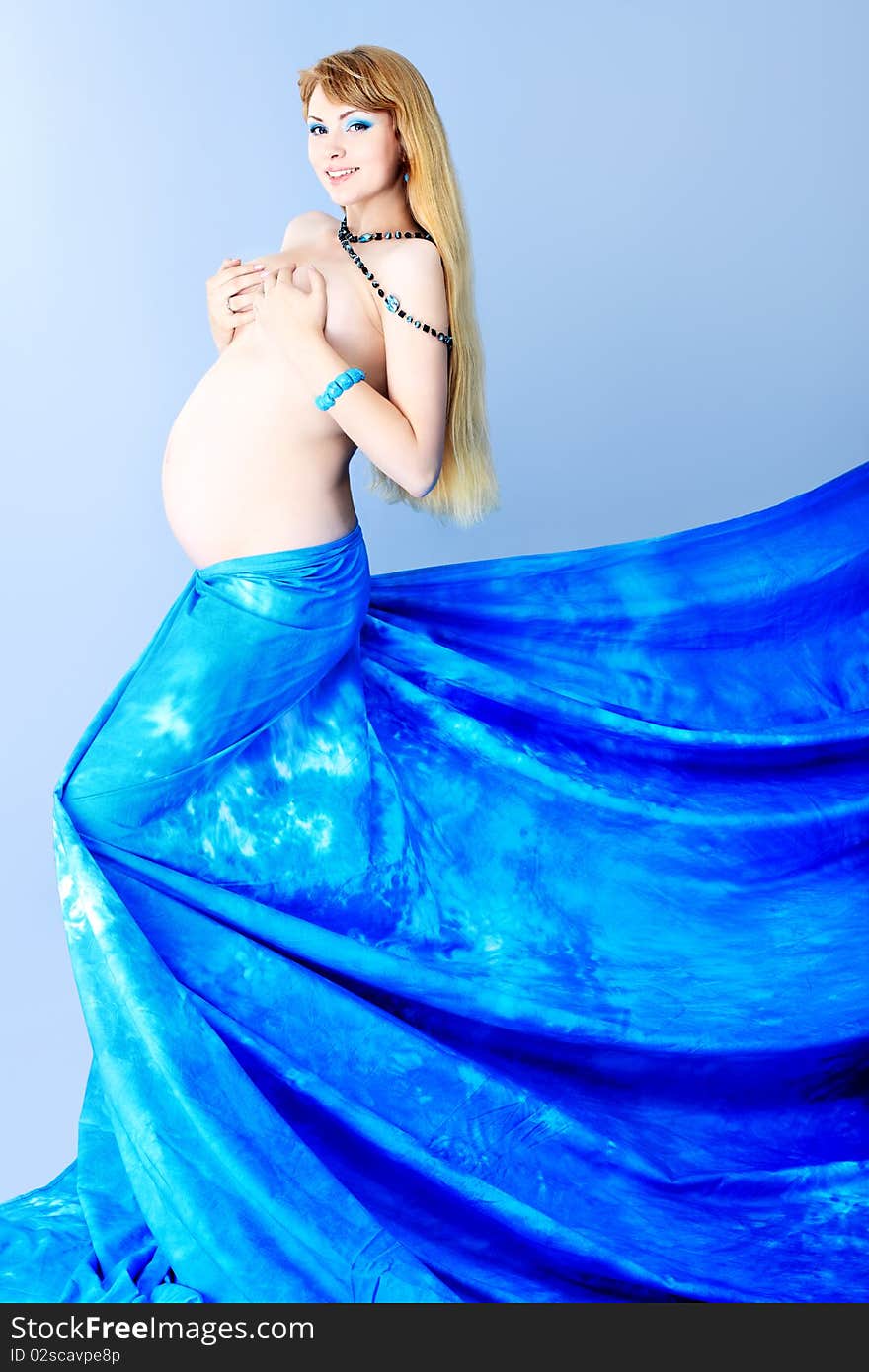 Portrait of a beautiful pregnant woman posing against grey background. Portrait of a beautiful pregnant woman posing against grey background.