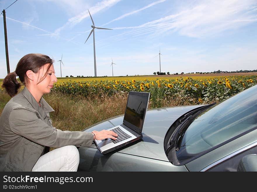 Agronomist in sunflowers field with wind turbines. Agronomist in sunflowers field with wind turbines