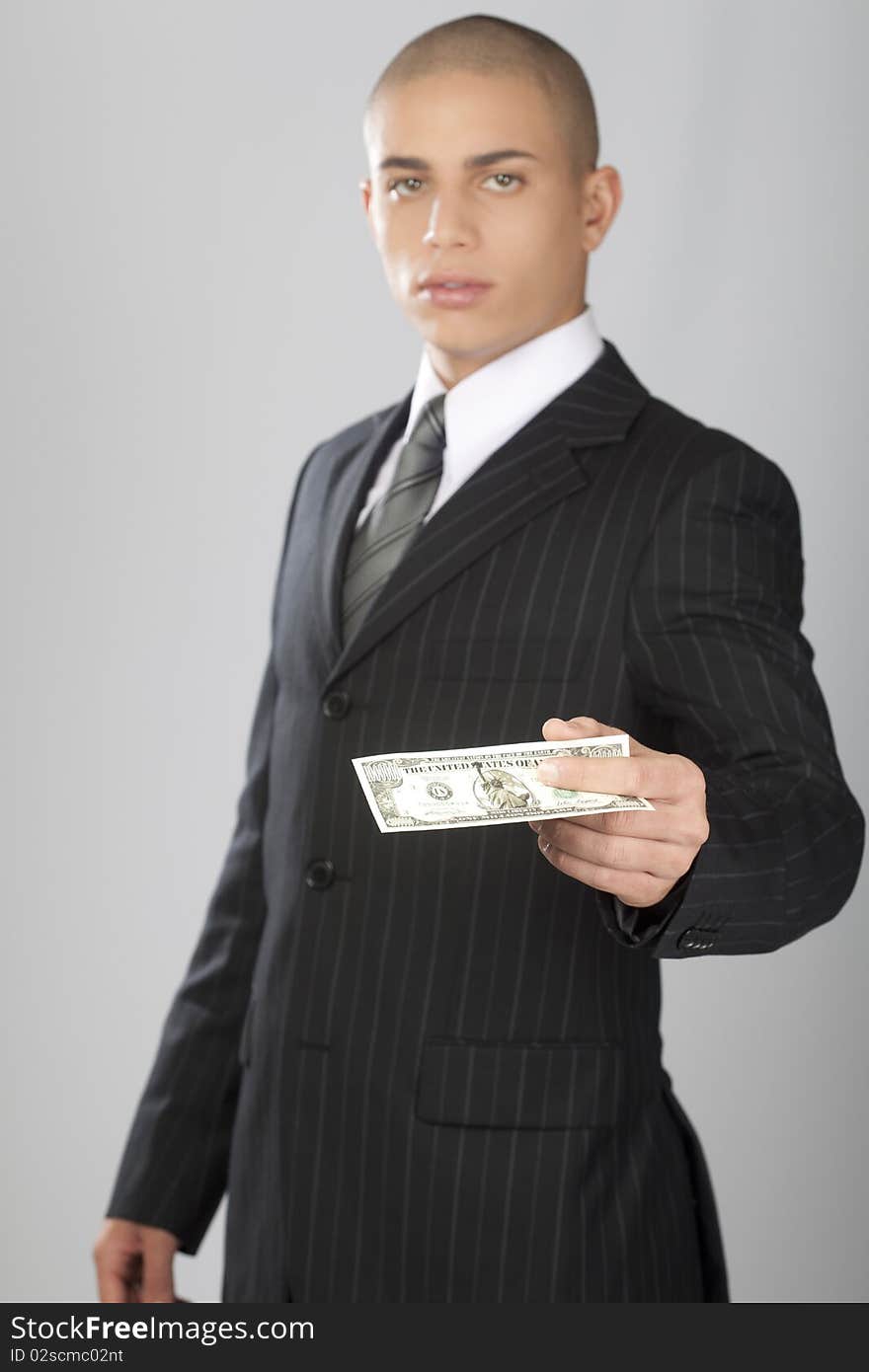 A young good looking businessman on a gray background. A young good looking businessman on a gray background.