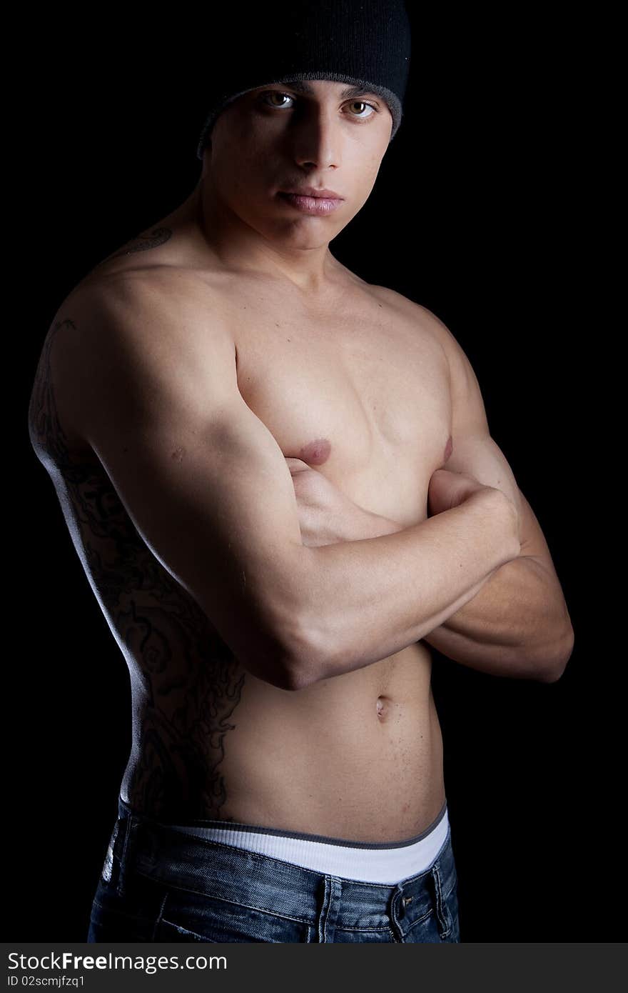 A good looking, muscular built, man on a black background. A good looking, muscular built, man on a black background.