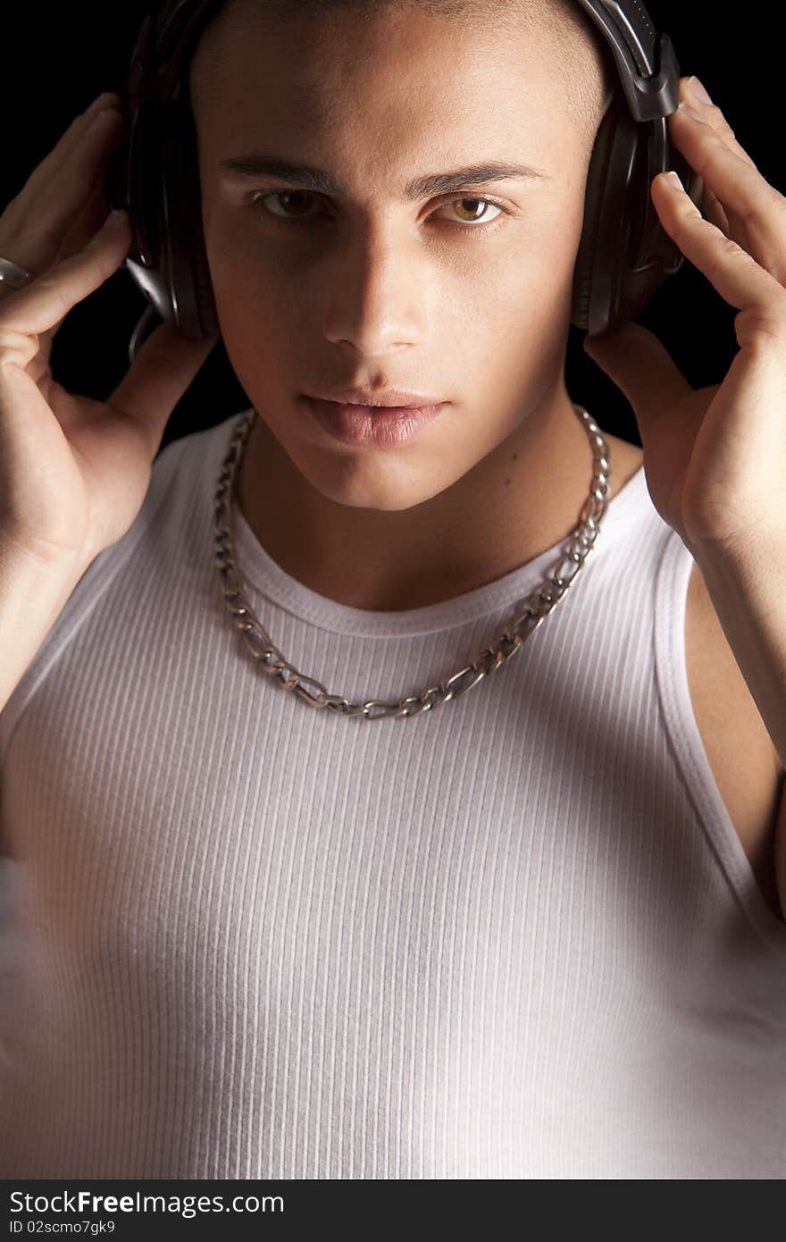 A good looking, muscular built, man on a black background with earphones. A good looking, muscular built, man on a black background with earphones.