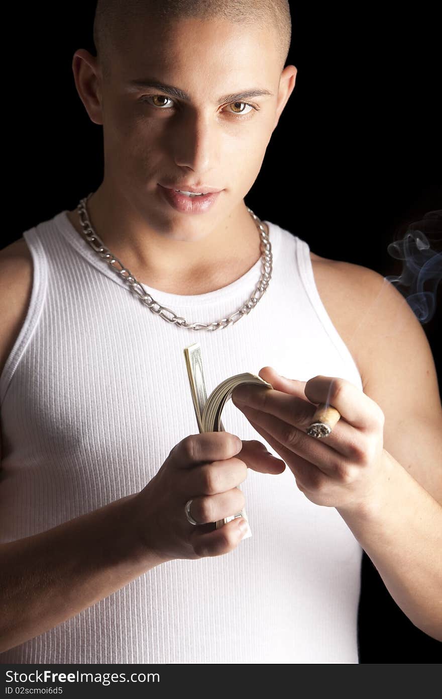 A good looking, muscular built, man on a black background smoking cigar. A good looking, muscular built, man on a black background smoking cigar.