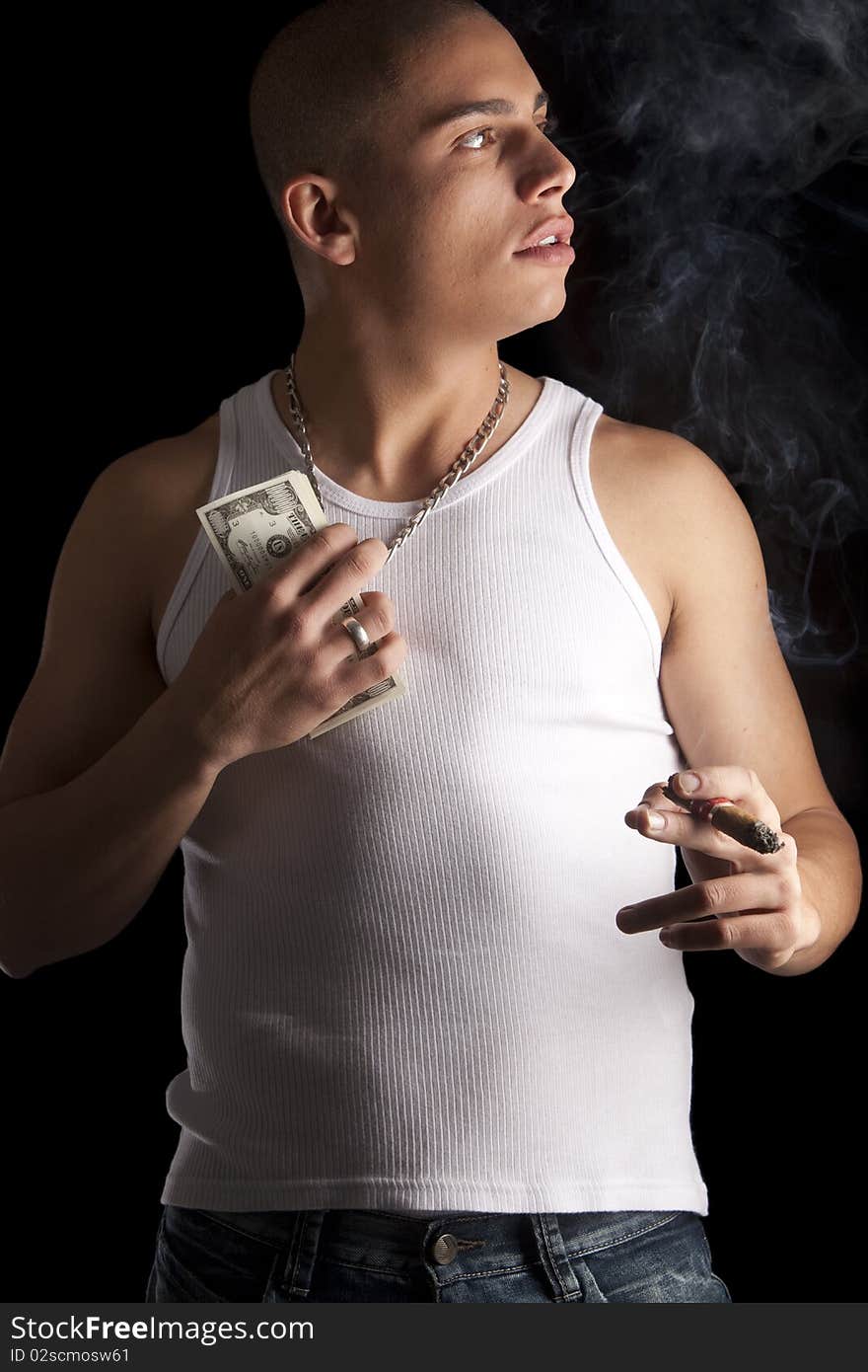 A good looking, muscular built, man on a black background smoking cigar. A good looking, muscular built, man on a black background smoking cigar.