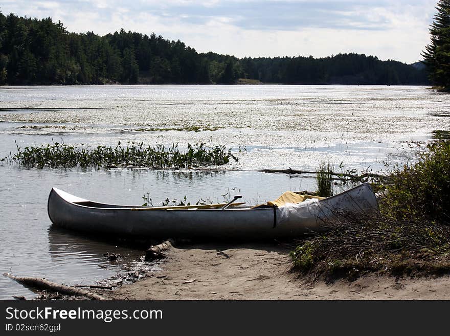 Aluminum Canoe sitting ashore off lake. Aluminum Canoe sitting ashore off lake.