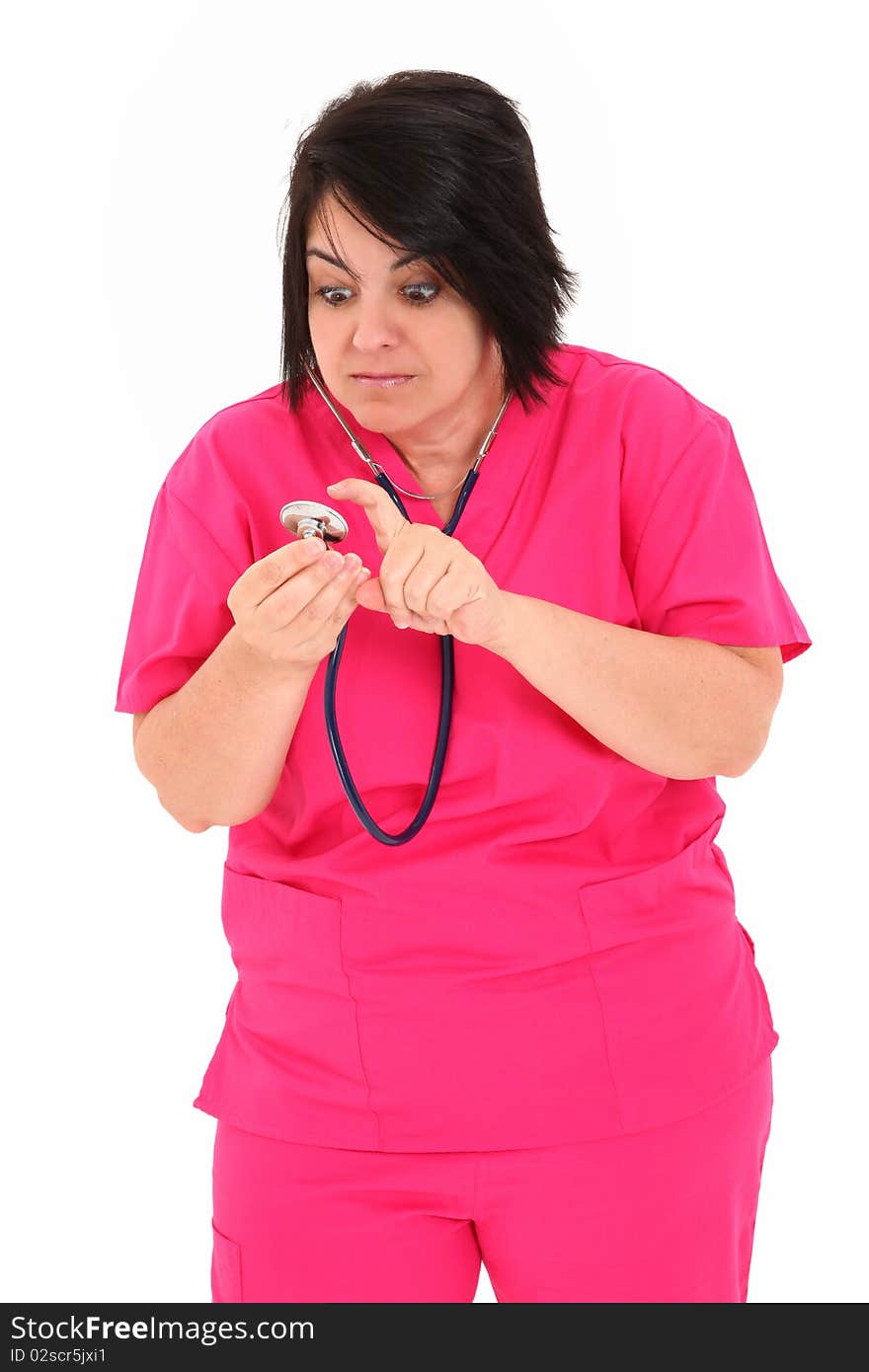 Attractive forty year old over weight nurse in pink scrubs with Stethoscope over white background.  Checking to see if stethoscope works. Attractive forty year old over weight nurse in pink scrubs with Stethoscope over white background.  Checking to see if stethoscope works.