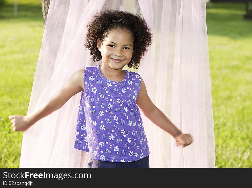 Little girl pushing the sides of the canopy behind her, posing. Little girl pushing the sides of the canopy behind her, posing