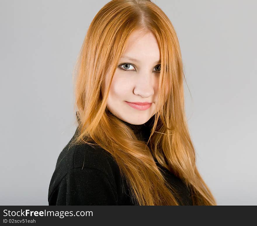 Young attractive girl in a black dress on a gray background. Young attractive girl in a black dress on a gray background